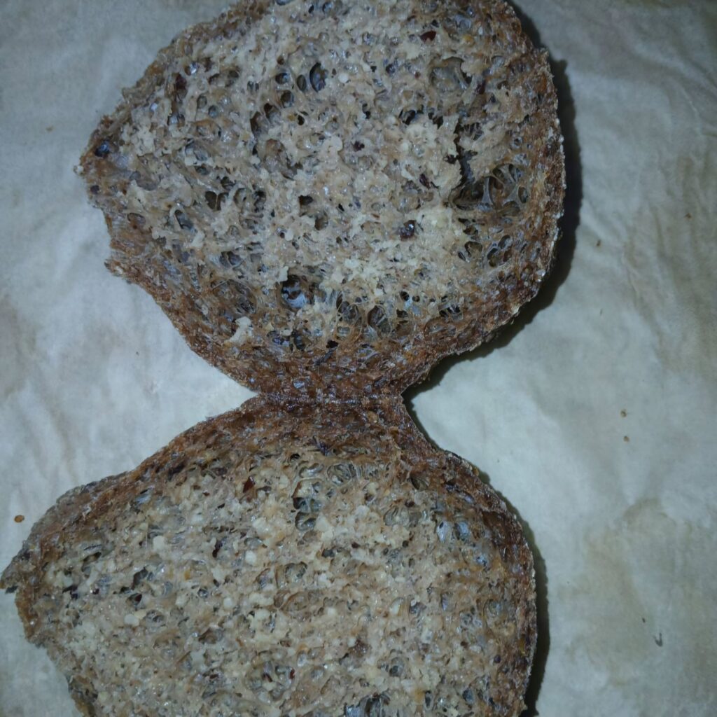 A sliced Millet and Oat Flour Bread, showing its soft texture and airy crumb, placed on parchment paper.