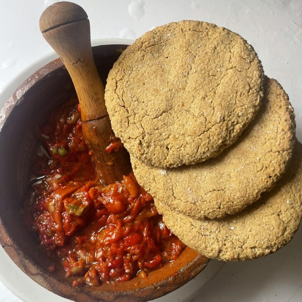 Oat rice flatbreads with roasted peppers served in a wooden bowl on a white plate.
