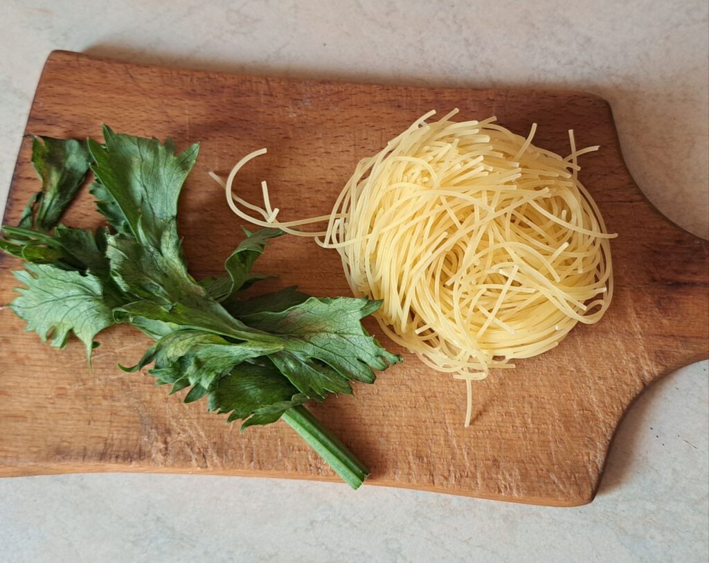Thin noodles and remaining celery prepared to add into soup pot.