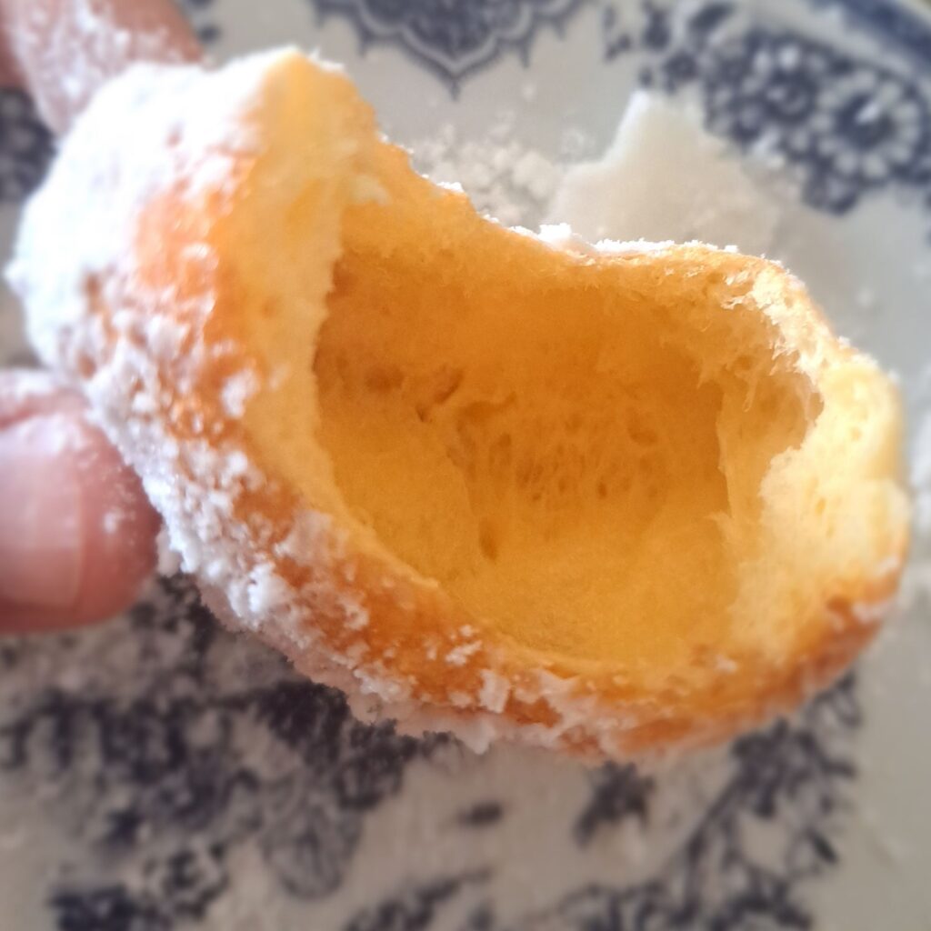 Close-up of a bitten Vanilla Sugar Donut showing its airy, soft, and fluffy interior.