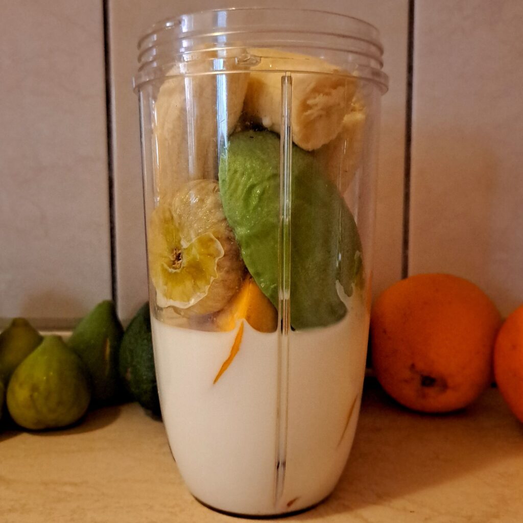 Ingredients for Avocado Fig Peach Smoothie in blender before blending.