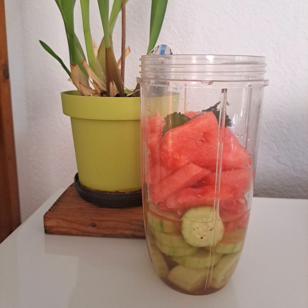 Cucumber, watermelon, lime juice, mint leaves, and water placed together in a blender cup.