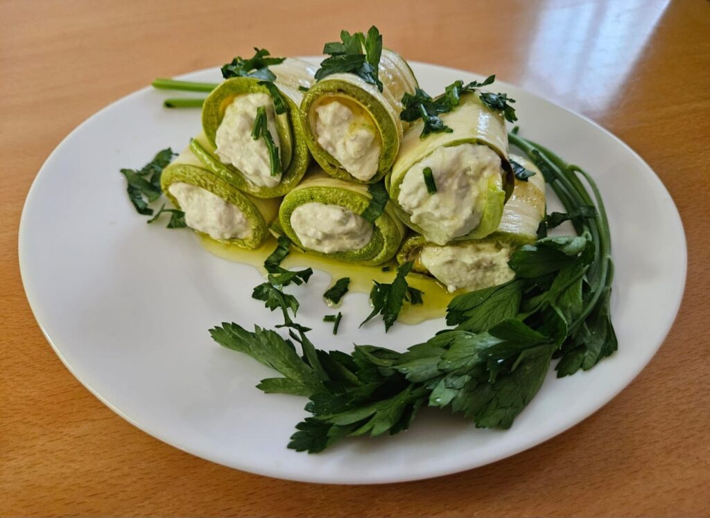 Rolled zucchini with avocado and cream cheese filling, beautifully arranged on a serving plate.
