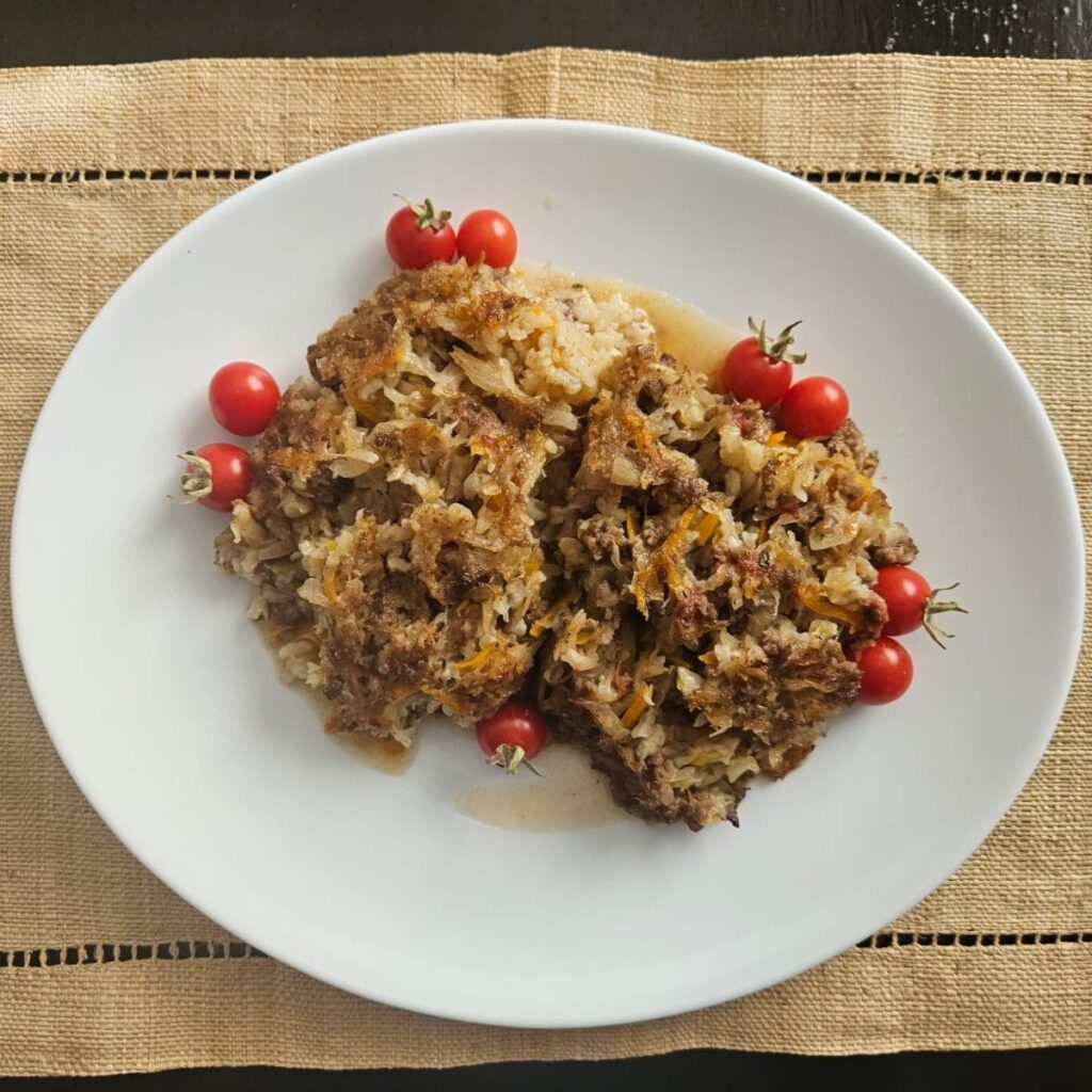Flat plate with Baked Cabbage Beef Rice, served with cherry tomatoes.