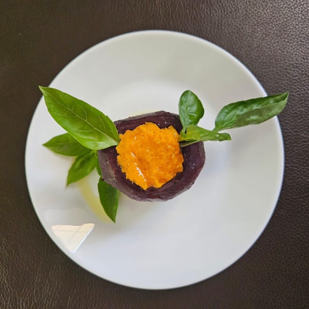 Overhead view of stuffed roasted beetroot with sweet potato puree served on a plate.