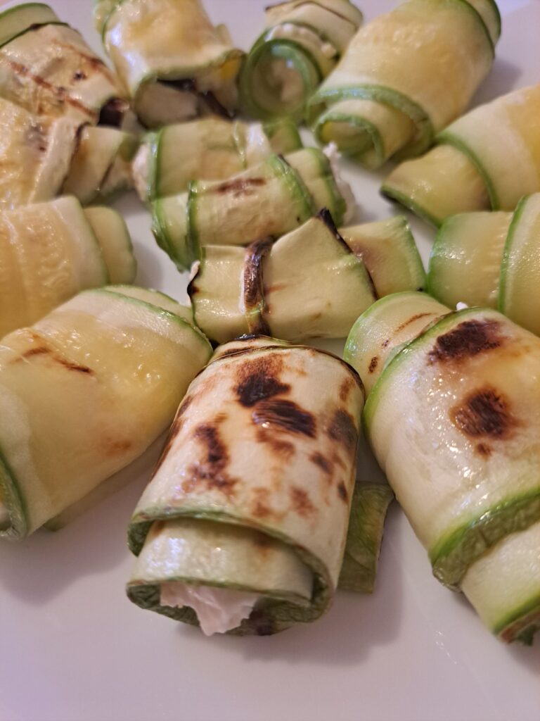 Close-up of zucchini rolls on a plate before adding microgreens.