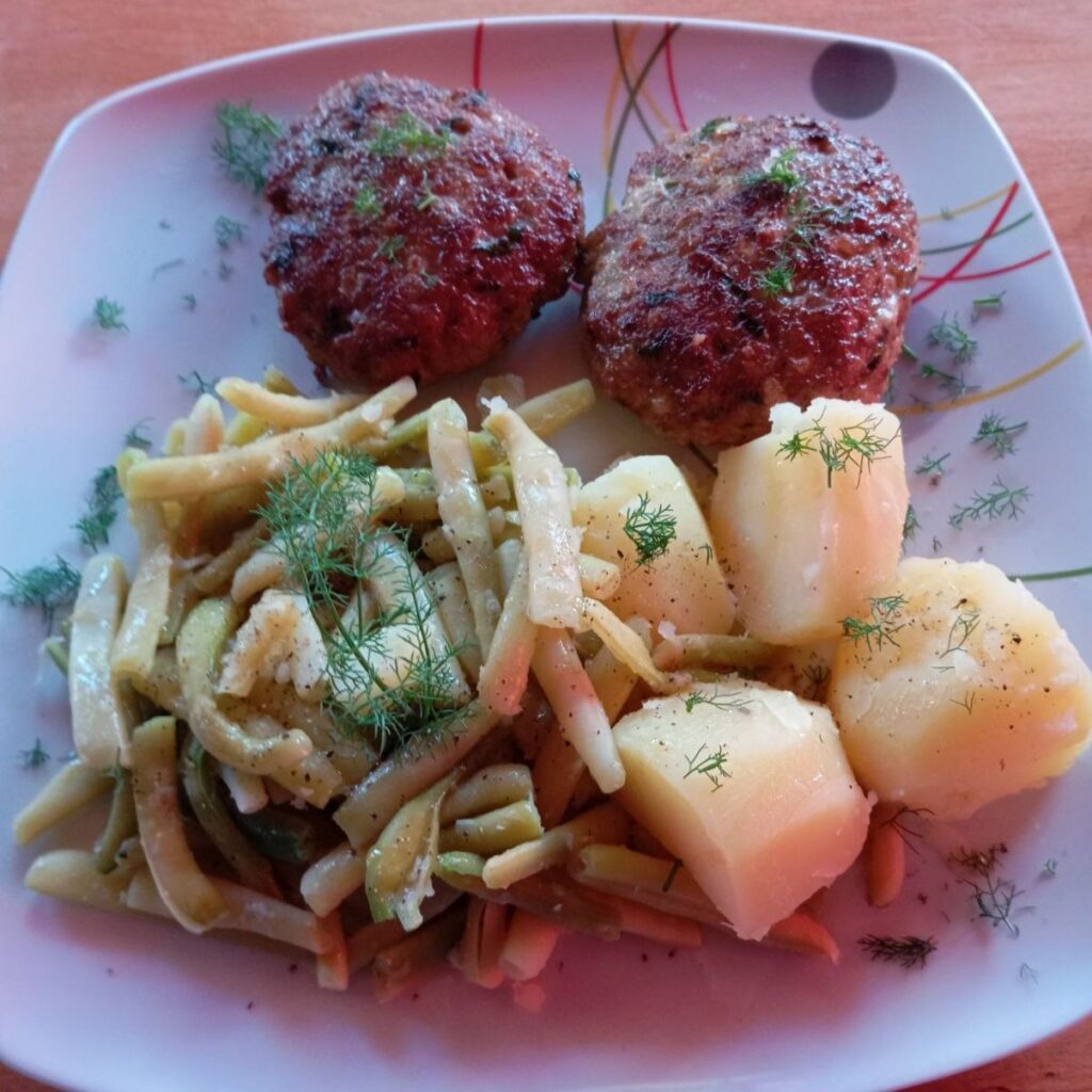 Plated Turkey Patties with Potatoes and Green Beans, garnished with fresh dill.
