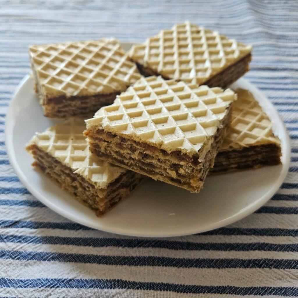 Square Walnut Biscuit Wafer Cakes served for a cozy home occasion, side view showing layers.