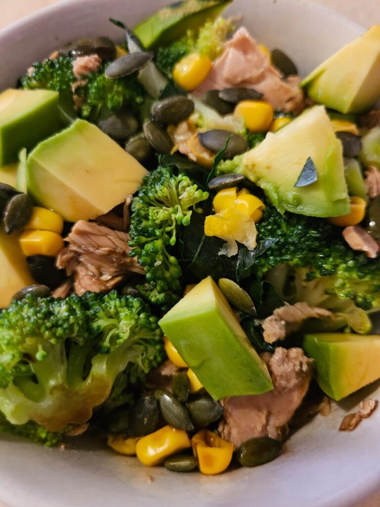 Close side view of Avocado Broccoli Tuna Salad in a small deep bowl.