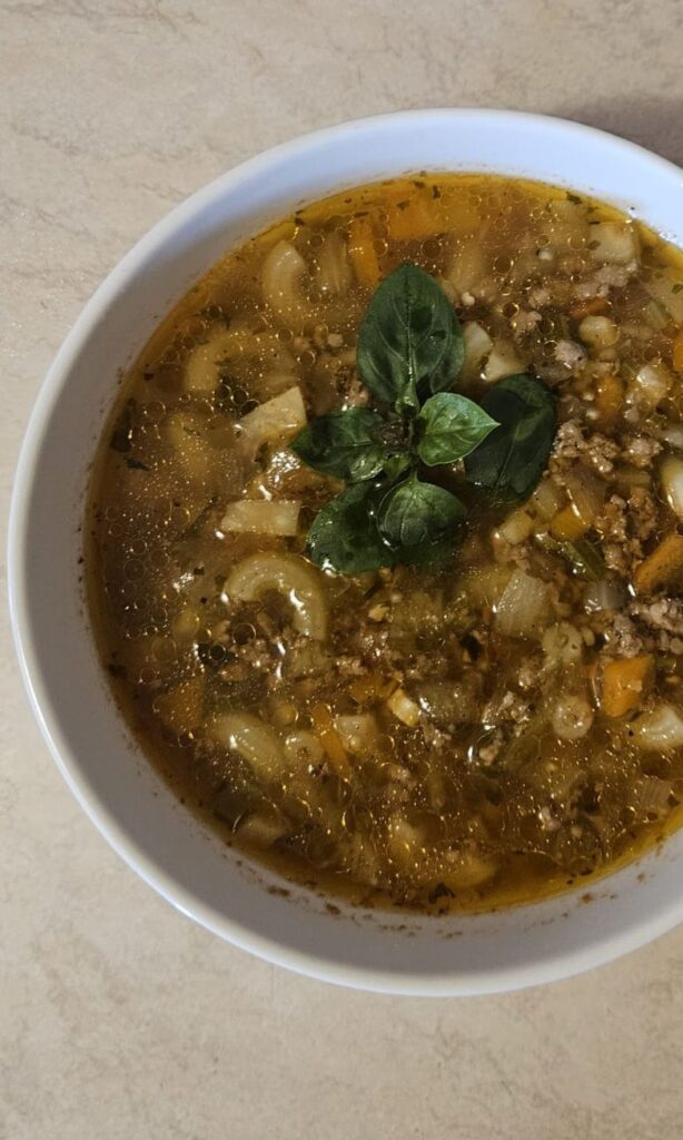 Beef Macaroni Vegetable Soup in deep bowl, close-up view.