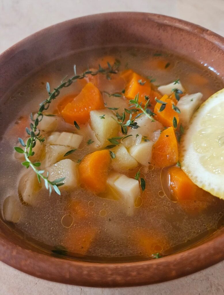 Close-up of root vegetable soup served in a ceramic bowl.