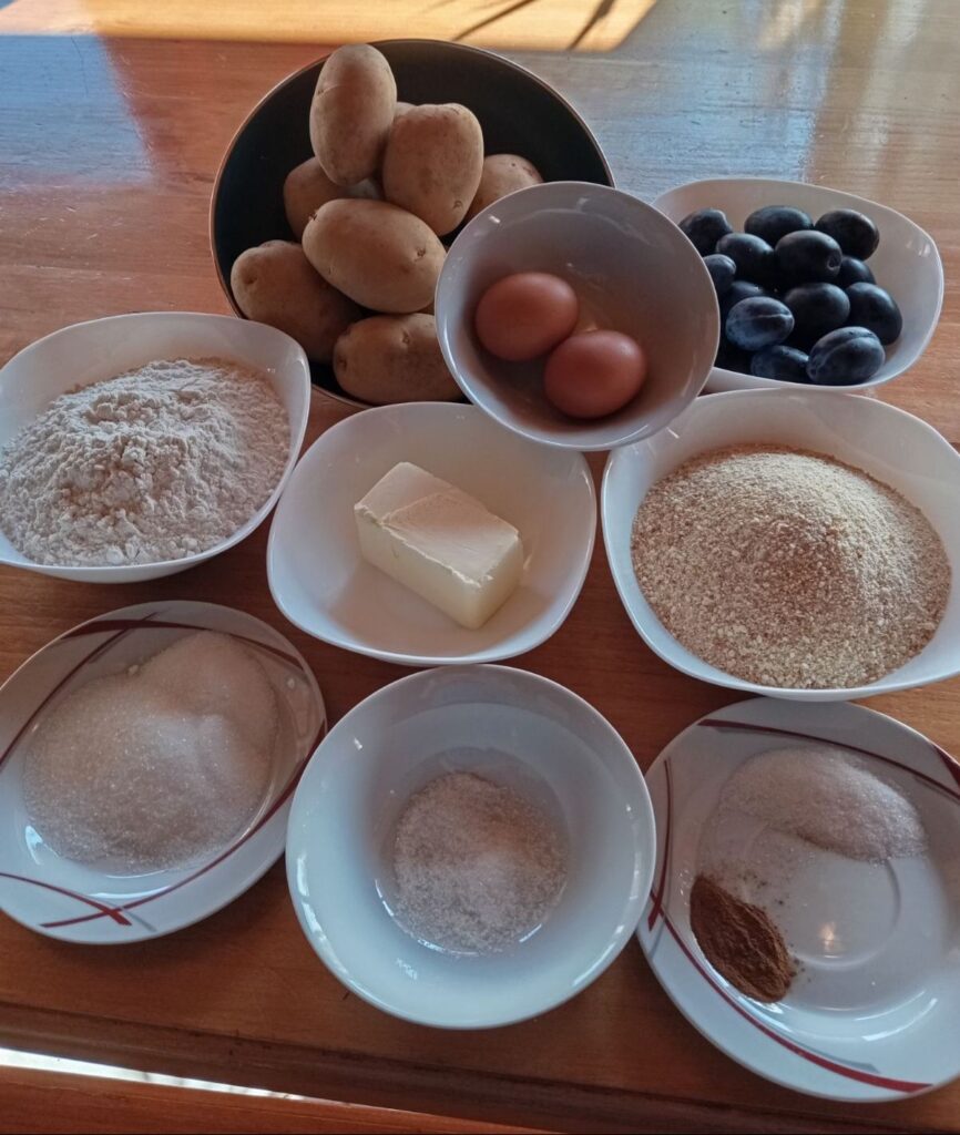 Measured ingredients for potato plum sweet dumplings arranged on a kitchen surface.