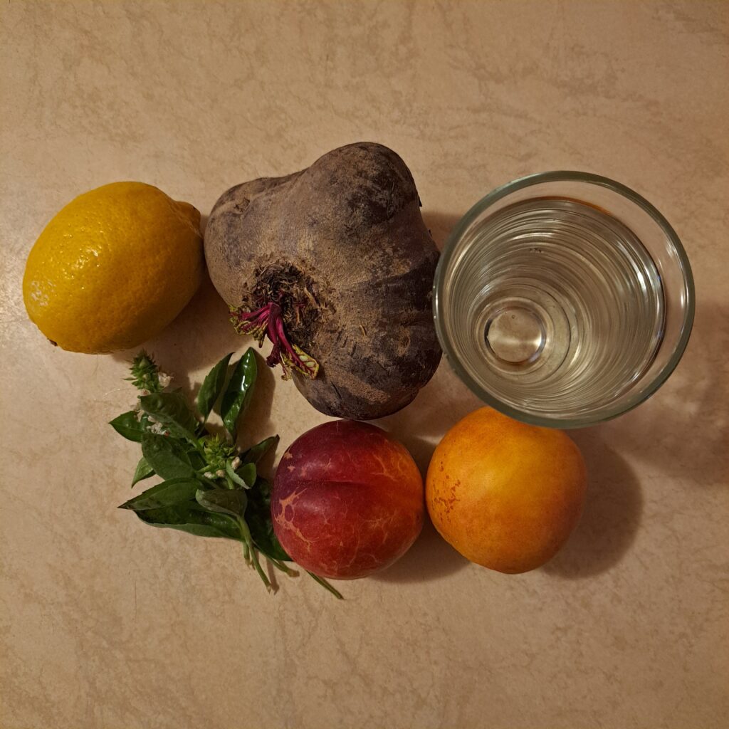 Whole beetroot, ripe peaches, basil leaves, lemon, and water prepared for making Beetroot Peach Basil Juice.