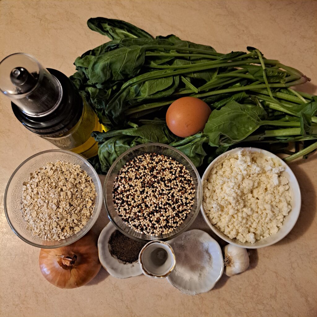 Quinoa, spinach, feta cheese, breadcrumbs, egg, salt, and black pepper arranged on a table.