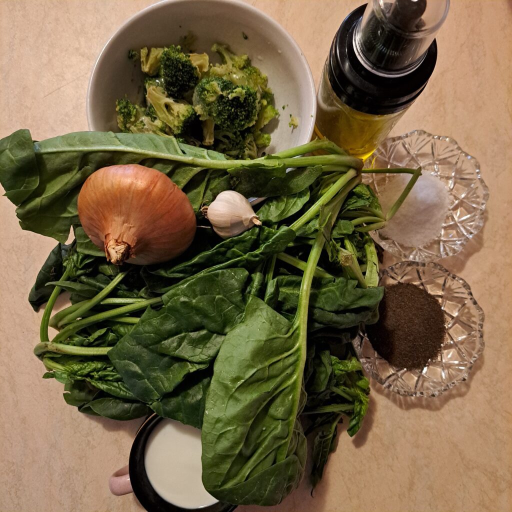 Fresh spinach, broccoli, onion, garlic, yogurt, olive oil, salt, and black pepper arranged neatly on a table.