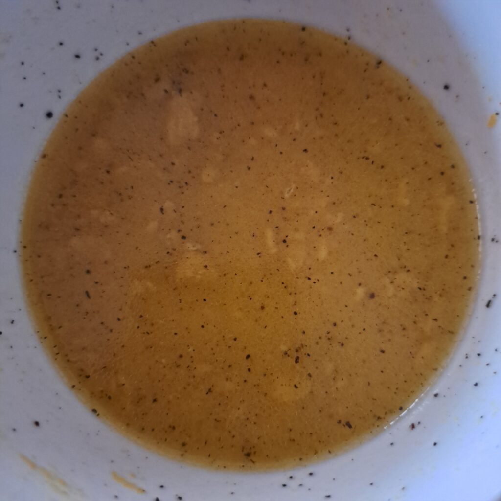 Close-up of finished citrus dressing in small bowl.