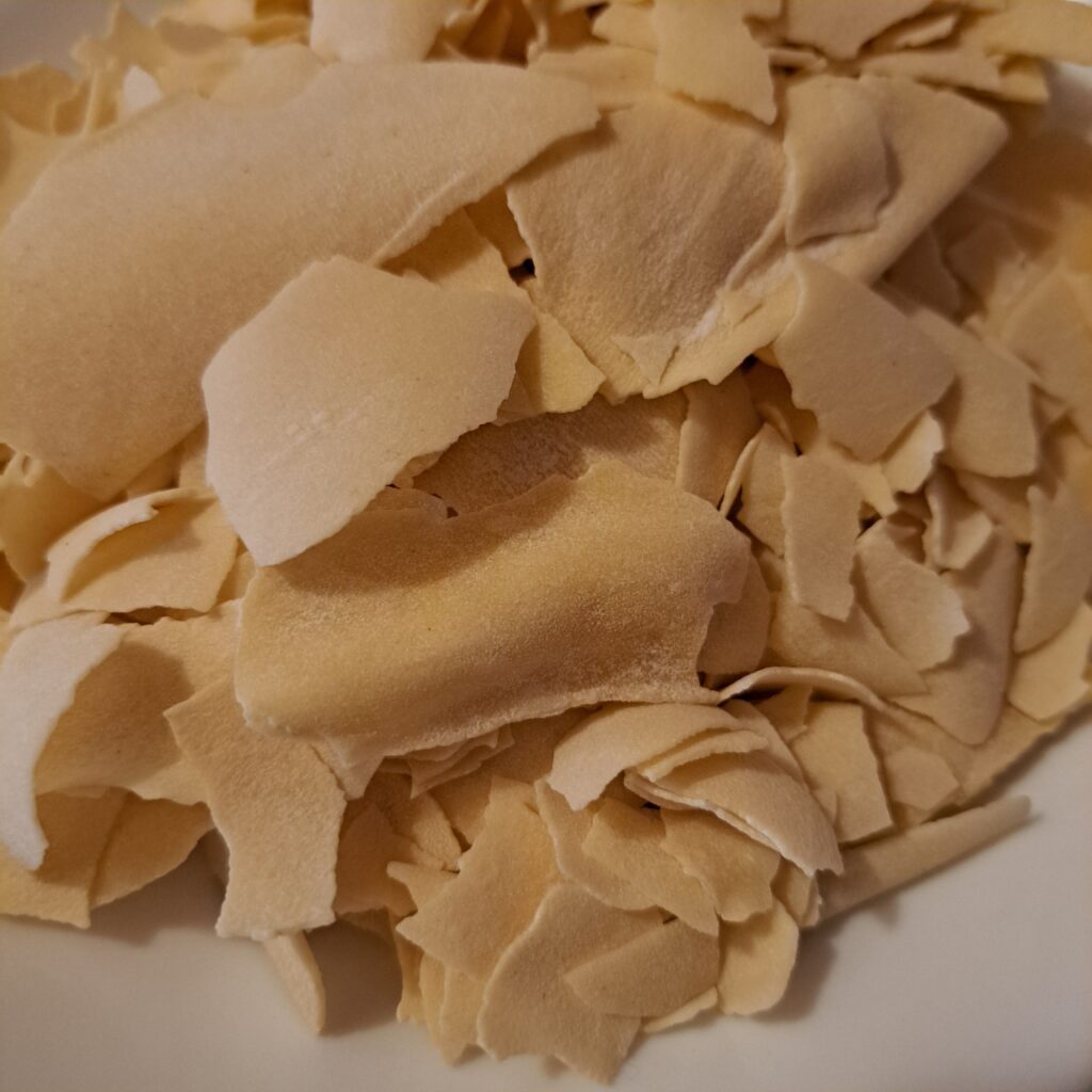 A close view of naturally dried and broken homemade pasta sheets.