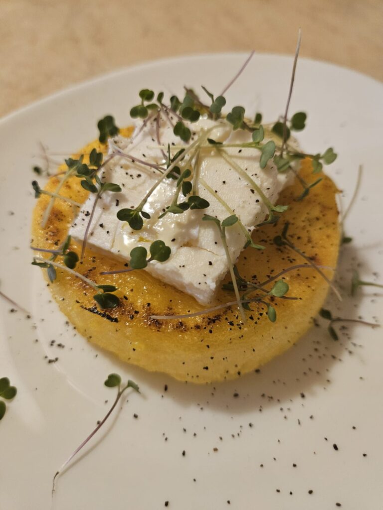 Polenta rounds served on a plate, captured in a close-up view, highlighting texture and presentation.