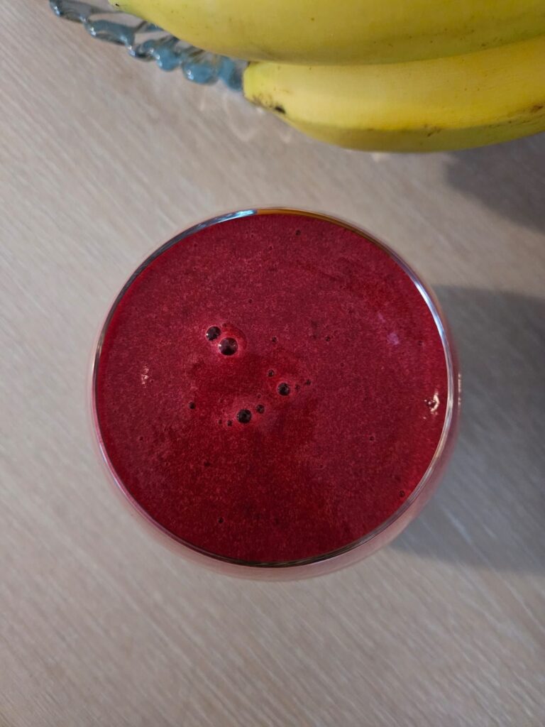 Top view of a glass filled with Beetroot Peach Basil Juice showing its vibrant color.