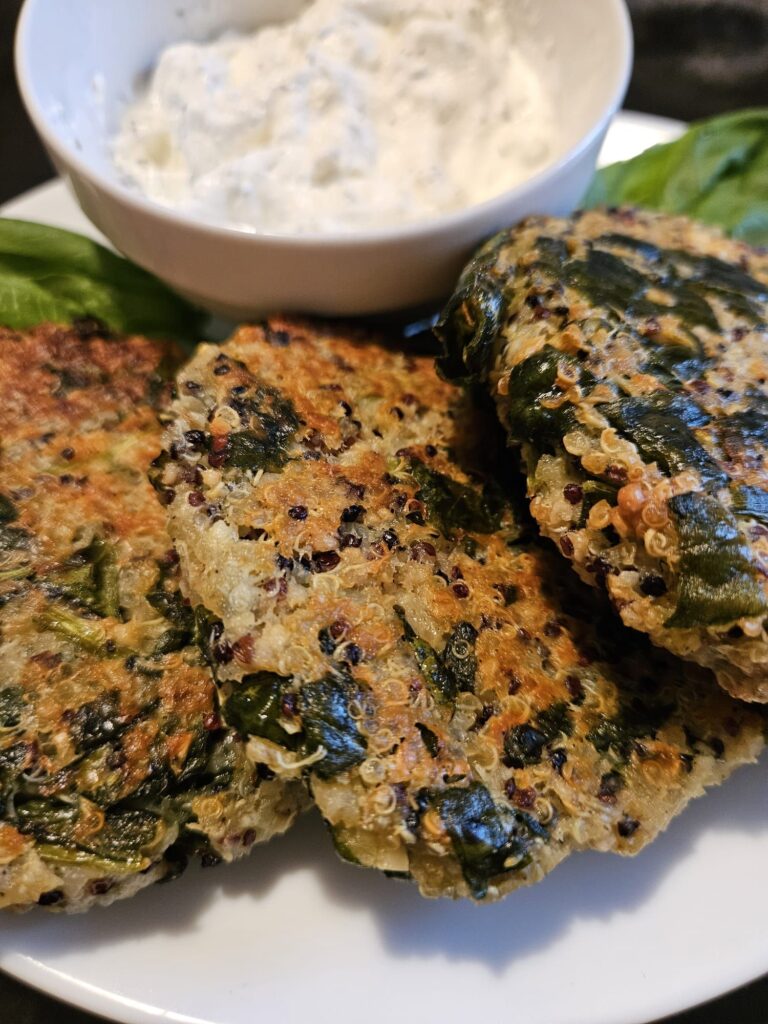 Close-up view of baked quinoa and spinach patties served on a plate.