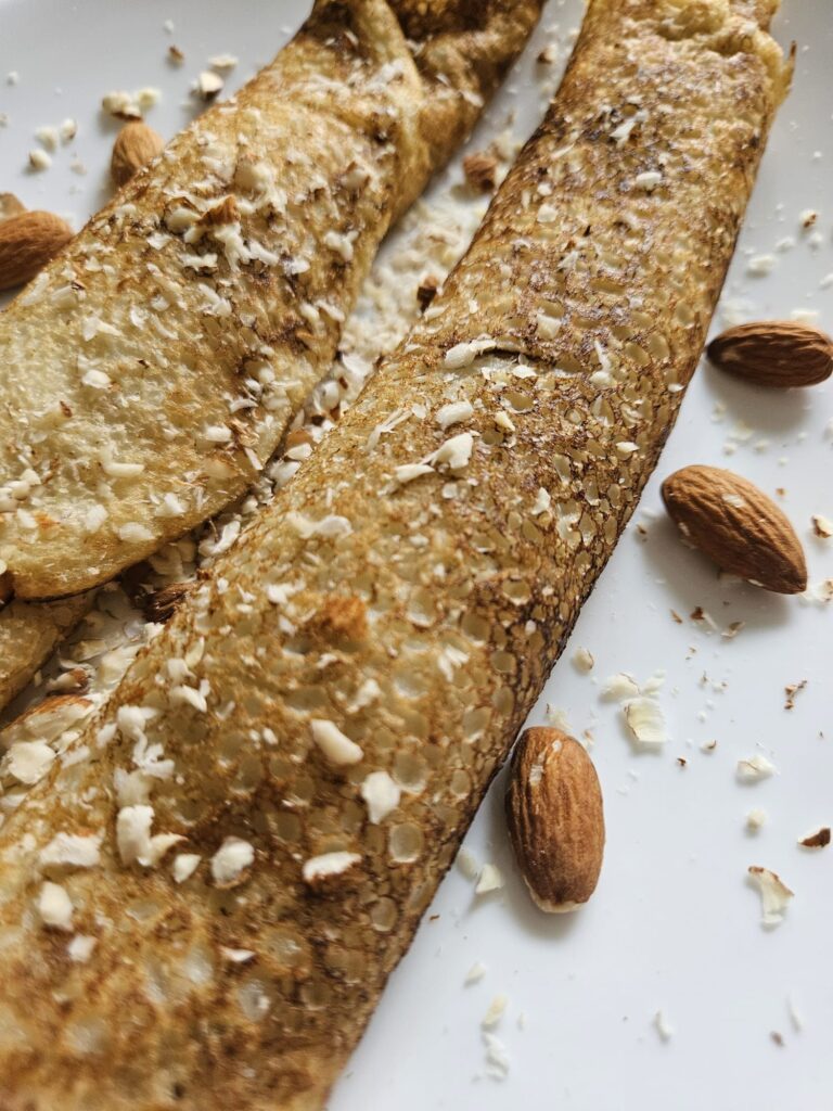 Whole Wheat Crepes with Apricot Jam and Almonds served and topped with chopped almonds.