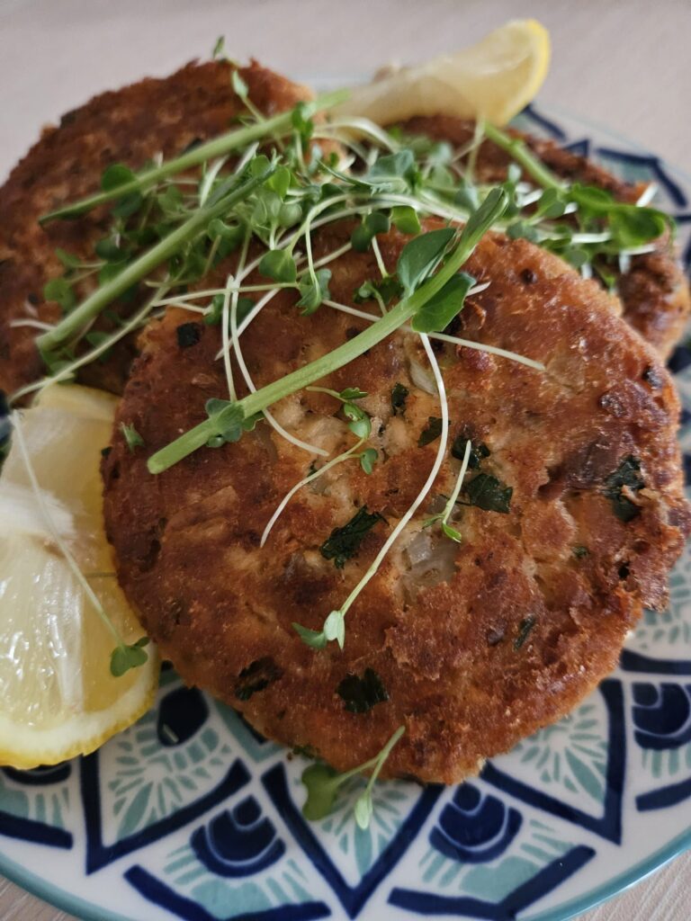 Close-up of Salmon Cakes with Microgreens served on a plate.