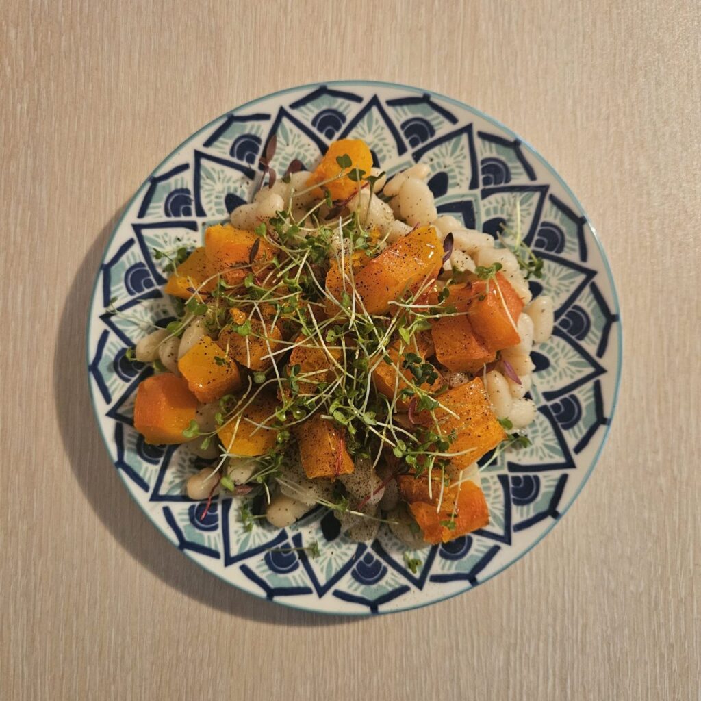 Beans Pumpkin Microgreens Bowl with tender white beans, roasted pumpkin cubes, and a colorful mix of microgreens.