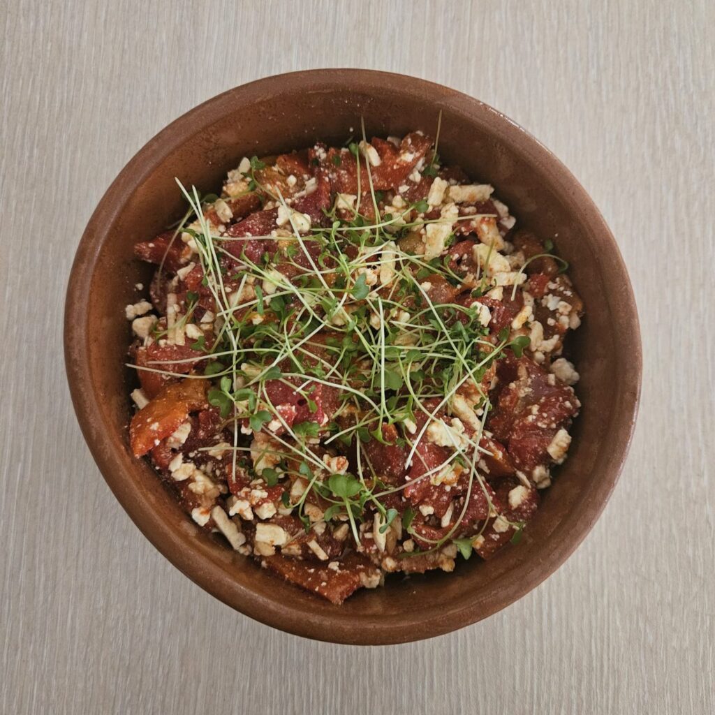 Fermented Red Pepper and Goat Cheese Mix beautifully served and decorated with microgreens.