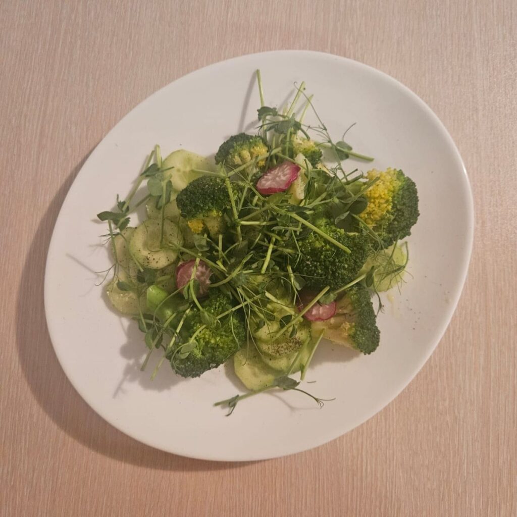 Fresh Vegetable Salad with Microgreens served in a white plate with pea microgreens.