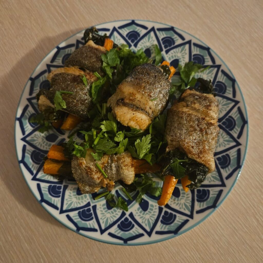 Fish Rolls with Carrot and Spinach served on a plate and garnished with fresh parsley.