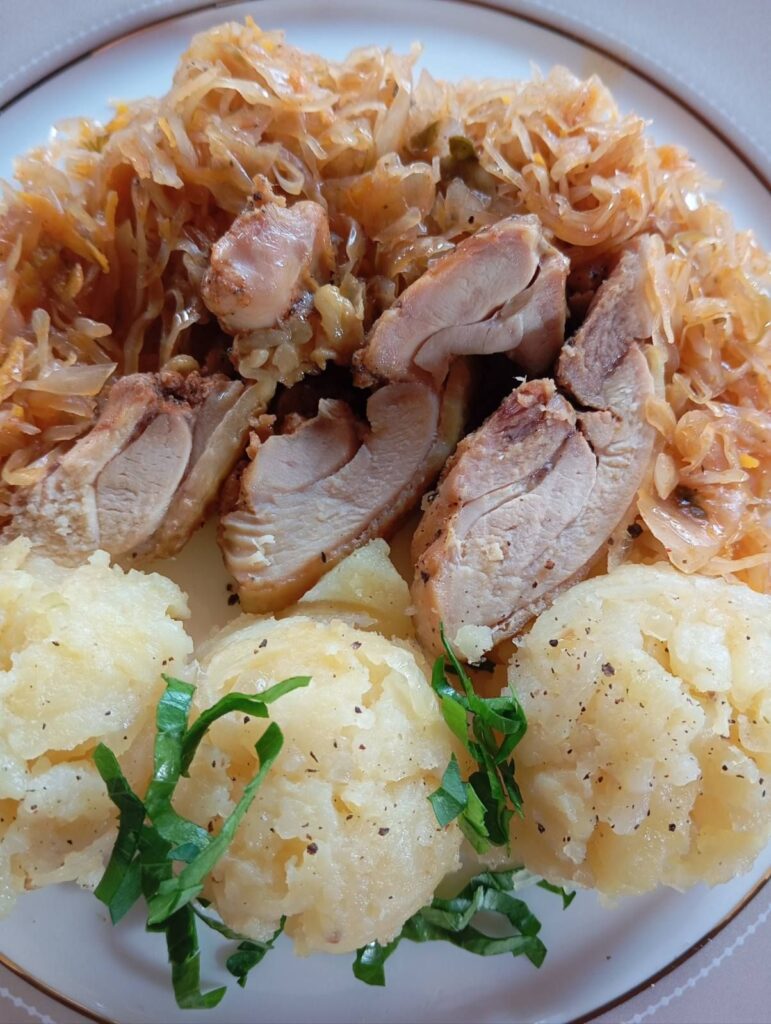 Close-up of Cabbage Chicken Potato Medley with braised cabbage, sliced fried chicken, and mashed potato balls, beautifully plated.