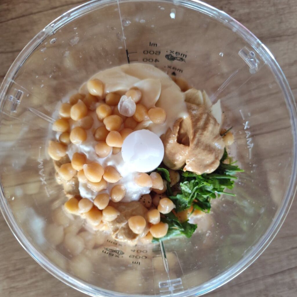 All ingredients for easy chickpea spread recipe placed together in a blender before blending.