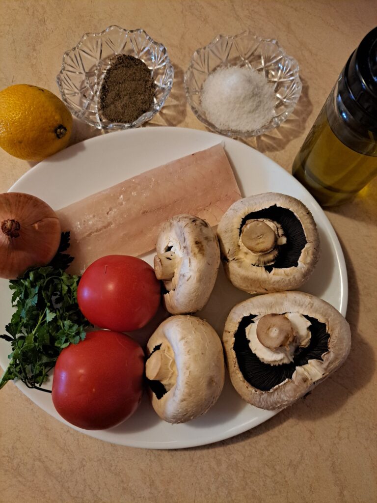 Ingredients for Fish Stew with Tomato and Mushrooms: fish fillet, mushrooms, tomatoes, onion, lemon, parsley, olive oil, salt, and pepper.
