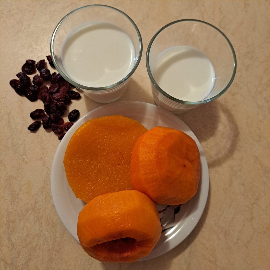 Ingredients for the Persimmon Butternut Cranberry Smoothie, including peeled persimmons, cooked butternut squash, dried cranberries, milk, and yogurt.