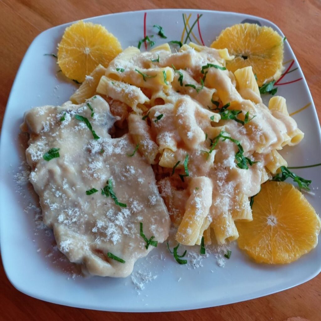 Creamy Pork Neck Rigatoni served on a flat plate, photographed close-up.