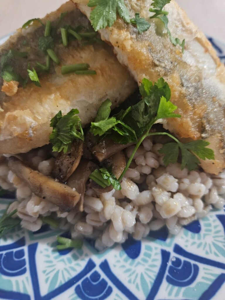 Seared Fish with Mushroom Barley served on a plate, captured close up to show texture and detail.