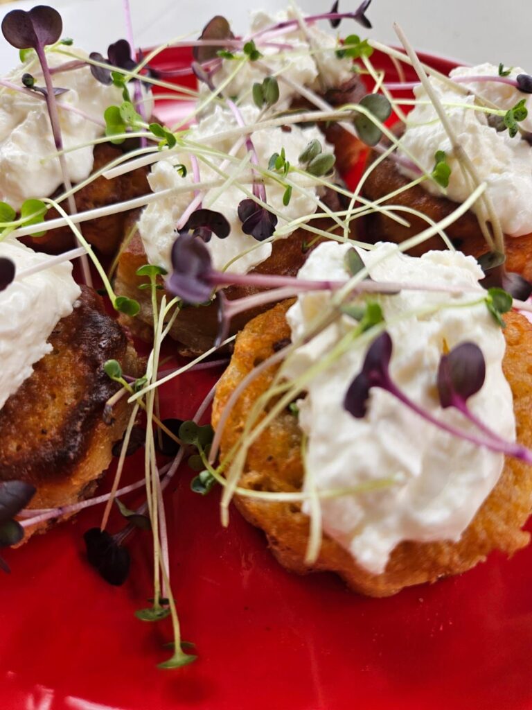 Several Oat Blinis with Ricotta and Microgreens arranged on a plate, showing their soft and creamy texture.