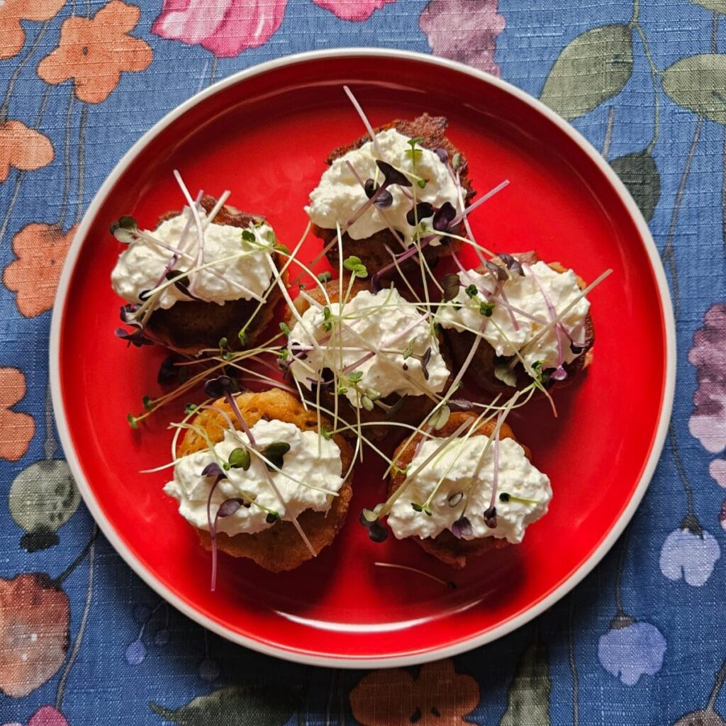 A served plate of Oat Blinis with Ricotta and Microgreens, beautifully decorated with a mix of fresh microgreens.