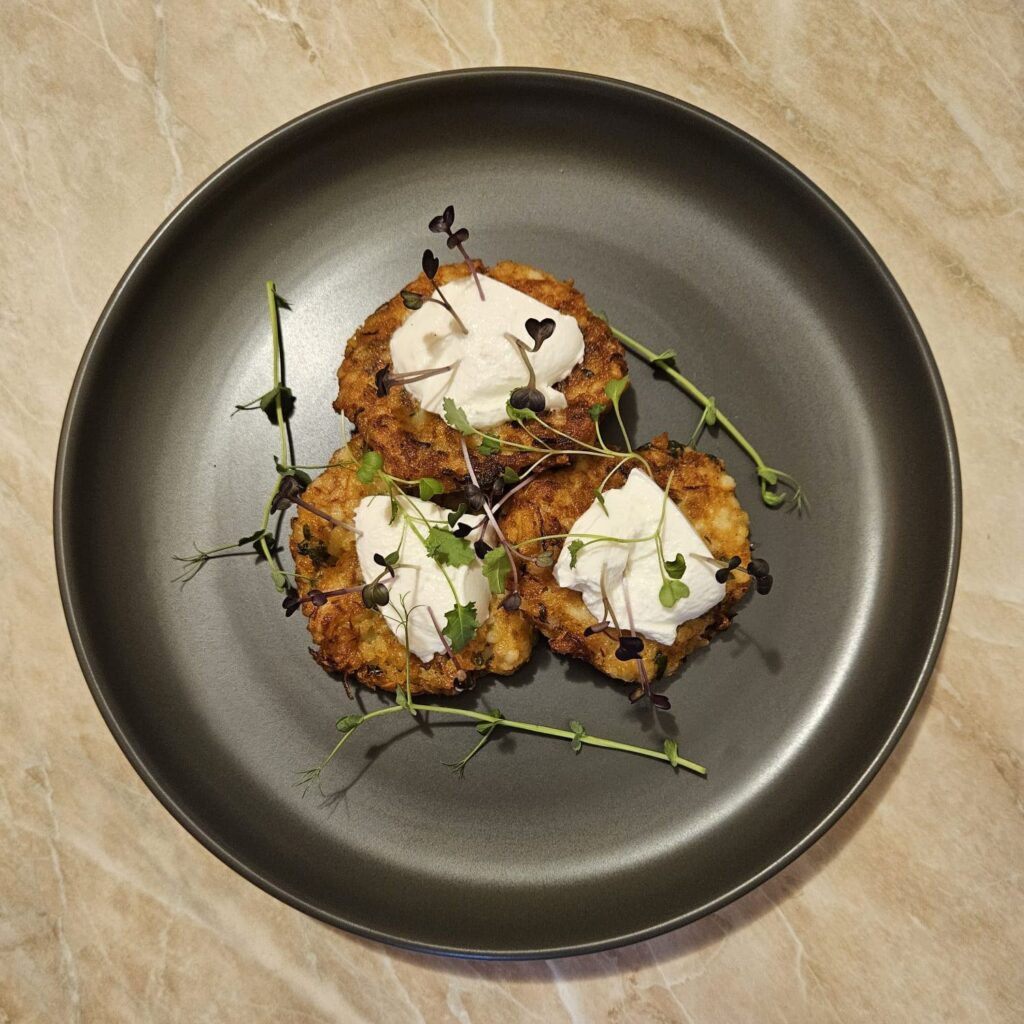A served plate of Millet Patties with Yogurt and Microgreens, beautifully decorated with colorful mixed microgreens.