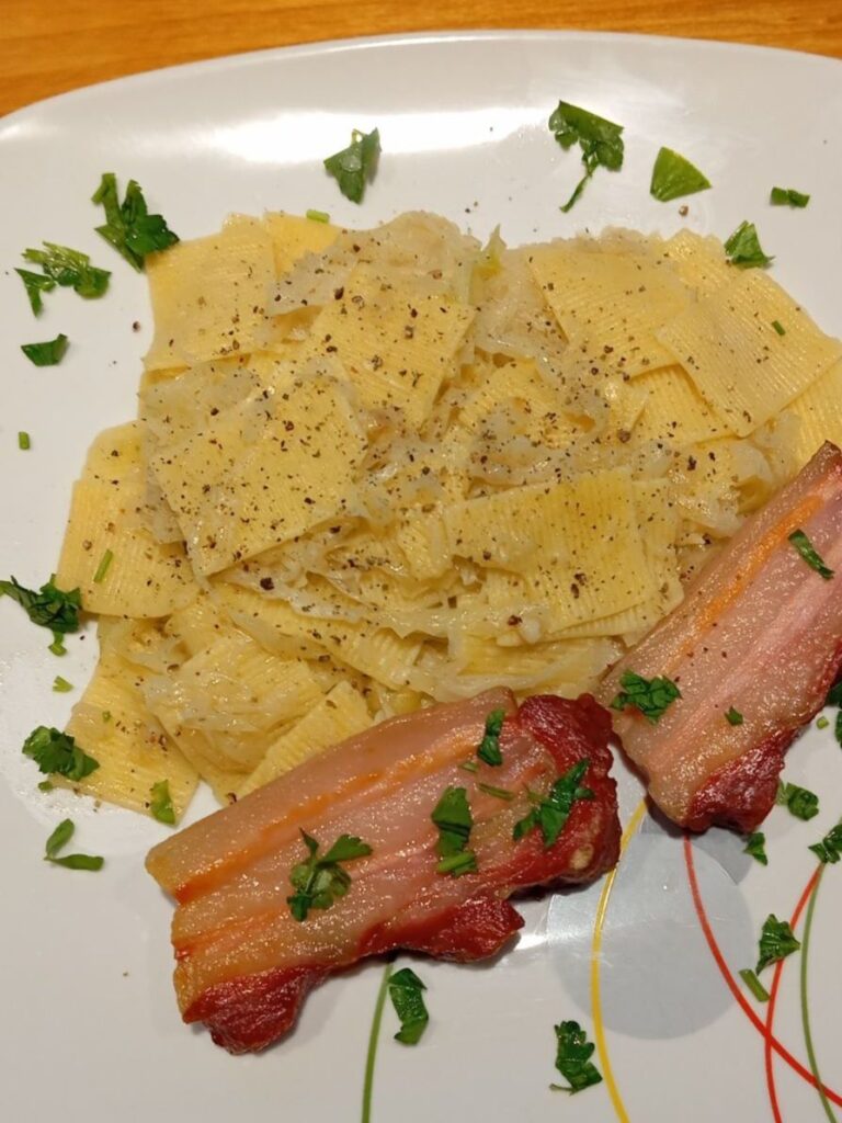 Close-up of a plate with Bacon Cabbage Pasta Squares, showing cabbage ribbons, pasta squares, and crispy bacon pieces.