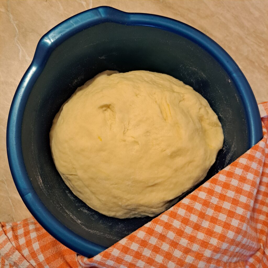 Soft, smooth dough prepared and resting in a bowl, ready for shaping flaky poppy seed rolls.