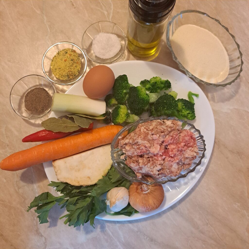 Fresh ingredients arranged for Beef Meatball Dumpling Soup including ground beef, vegetables, semolina, egg, and seasonings.