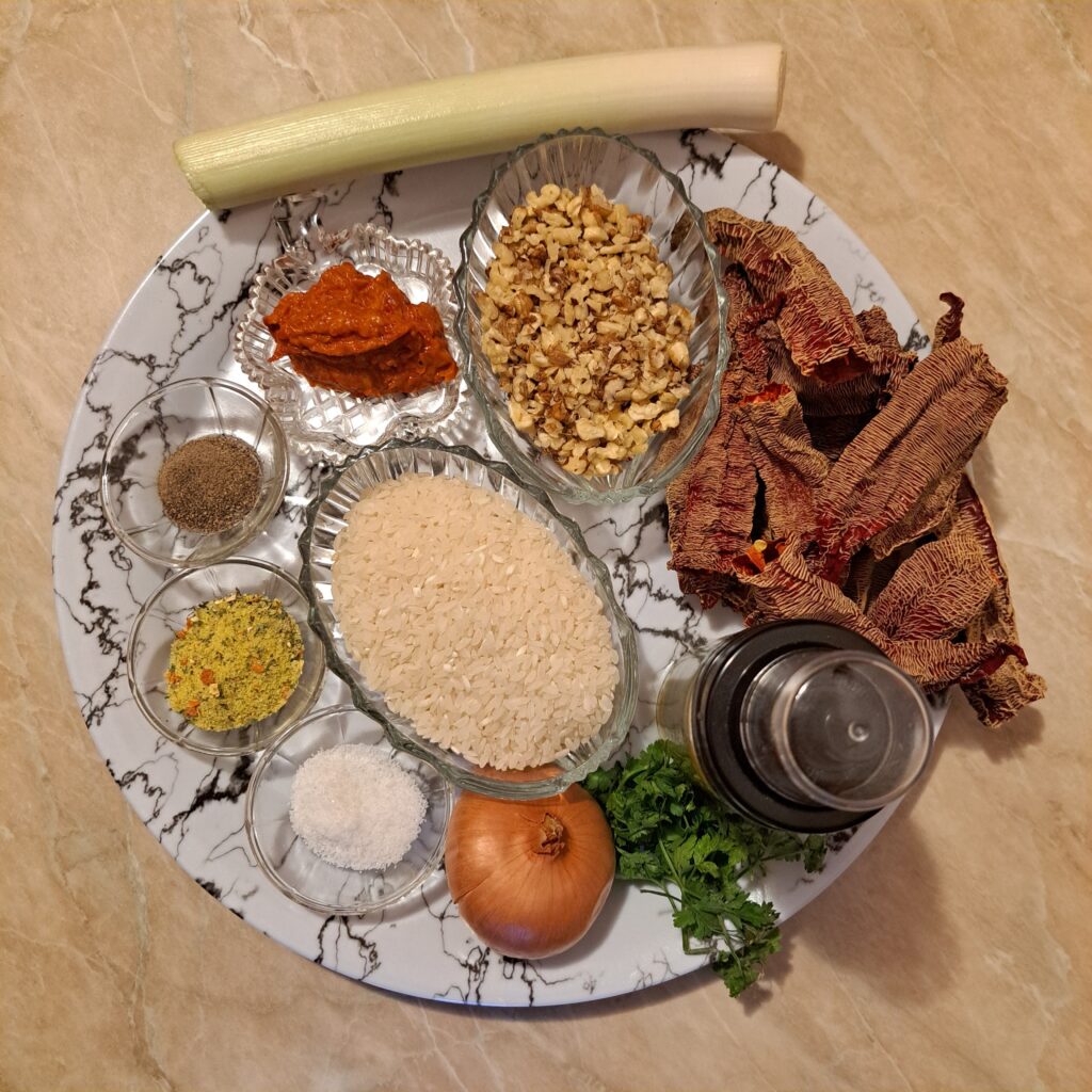 Ingredients for meatless stuffed dried peppers arranged on a large flat plate before cooking.