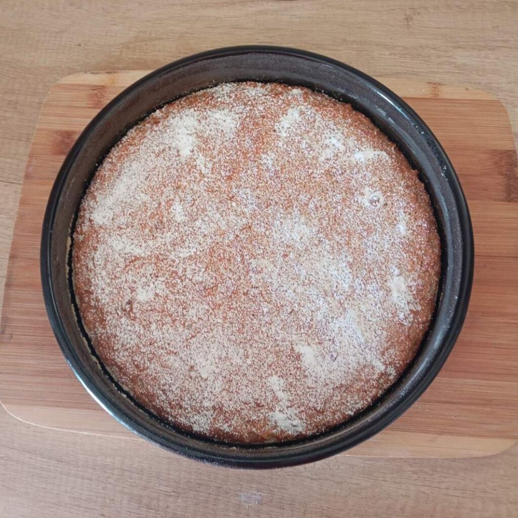 Homemade Soft Apple Cake topped with powdered sugar after baking.