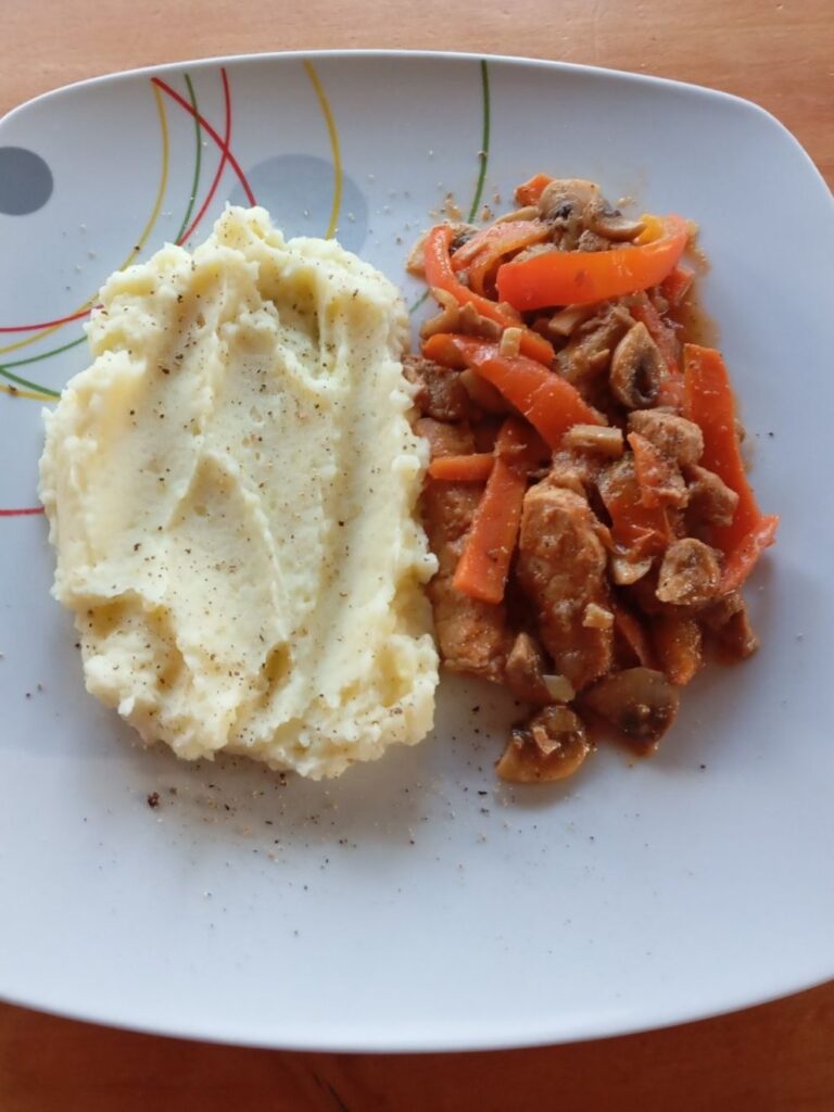 Close-up of a plated Braised Pork Vegetables Dish served together with creamy mashed potatoes in the same dish.