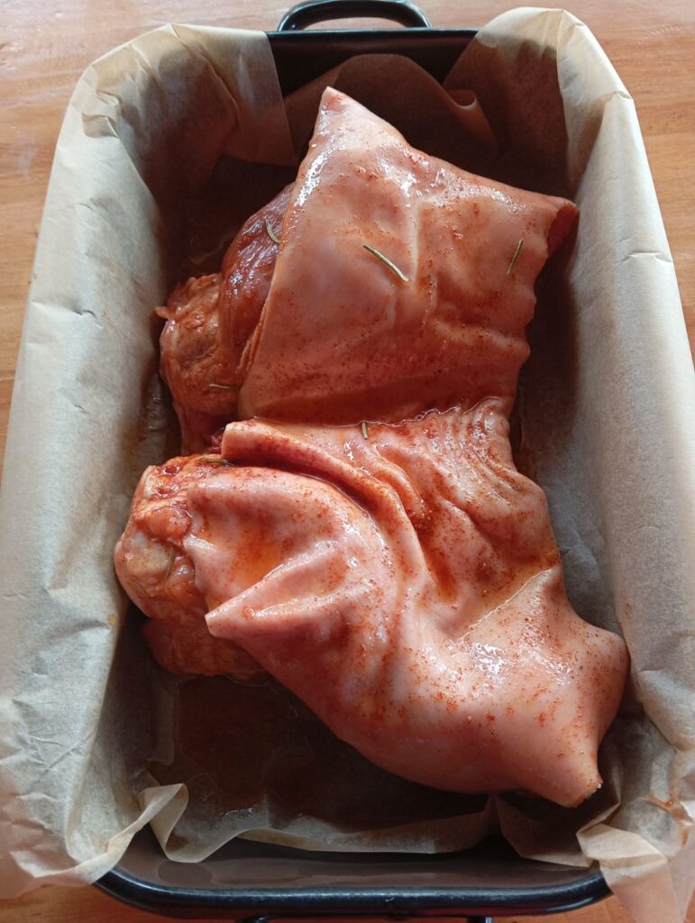 Pork shank placed in a baking tray, fully prepared for roasting.