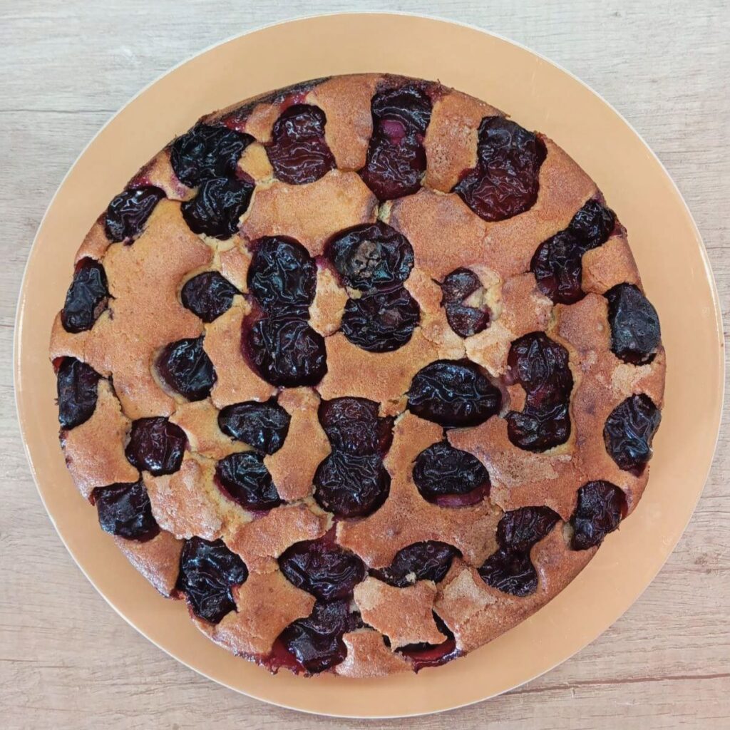 The cake carefully removed from the pan and placed on a flat plate, showing its shape and texture before finishing.