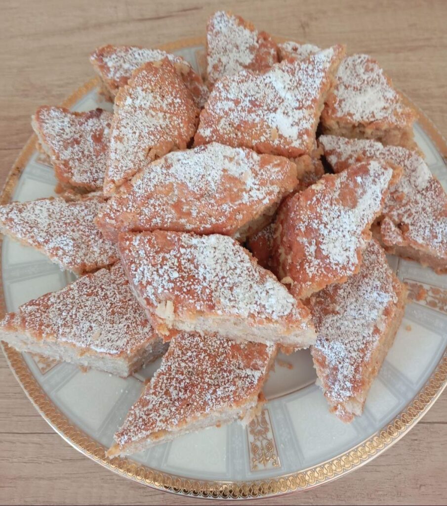 A full plate of Homemade Soft Apple Cake slices, ready to serve and lightly dusted with powdered sugar.