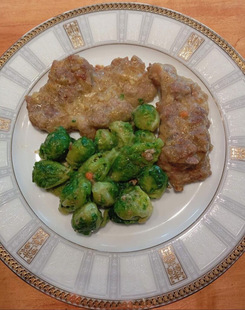A close-up view of a Brussels Sprouts Pork Schnitzel served on a plate, showing golden pork and tender sprouts.