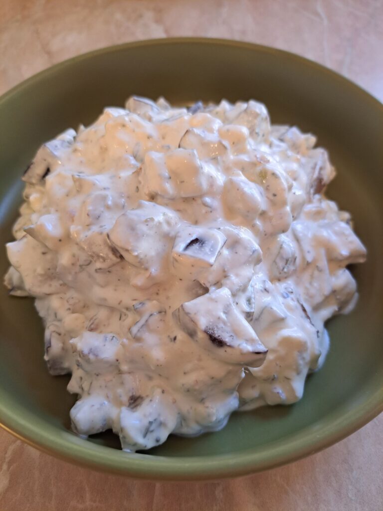 Creamy eggplant walnut salad in green bowl, ready to enjoy.